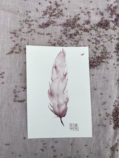 Plume de couleur mauve sur un fond blanc peinte avec du vin rouge.