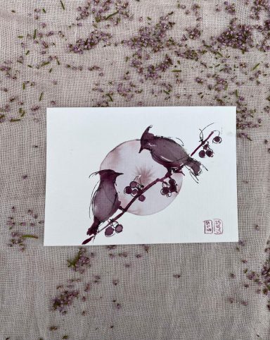 Deux oiseaux noirs perchés sur une branche devant une lune pleine.