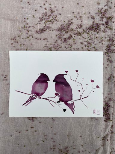 Deux oiseaux roses perchés sur une branche avec des fleurs.